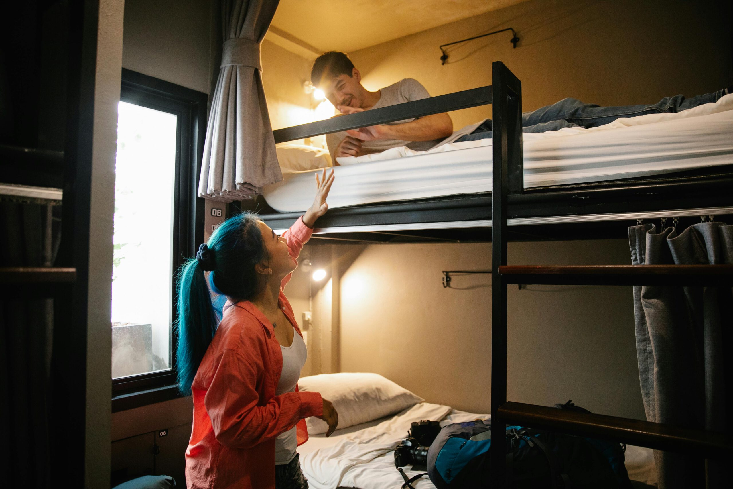Young couple enjoying a cozy stay in a hostel bunk bed room, perfect for budget travel and bonding, billigreisen hagenberg, studentenreisen hagenberg
